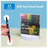 A set of 12 soft hard dual head brush pens in various colors displayed next to a hand.