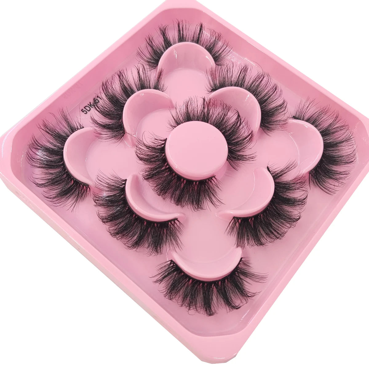 A pink plastic tray holding a set of black artificial mink eyelashes