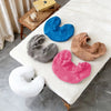 A collection of reusable U-shape pillow covers in various colors including blue, gray, tan, and pink resting on a white surfa