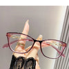 Gros plan de lunettes à œil de chat roses avec accents dorés tenues par une main, sur fond clair.