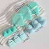 A set of twelve light blue makeup sponges arranged on a white tray with various sizes.