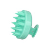 A light mint green silicone scalp massage and body brush with numerous pointed bristles.