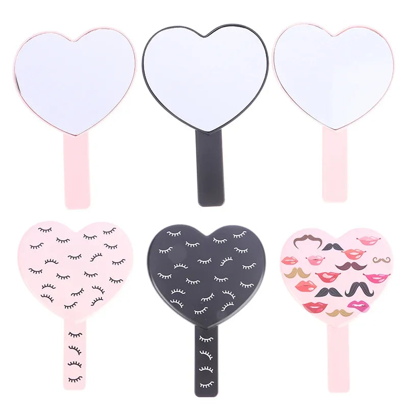Un set de quatre miroirs pour cils en forme de cœur, roses et noirs.