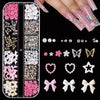 A collection of pink and white rhinestones, pearls, and charms for nail art decoration.