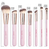 A set of seven pink makeup brushes with varying sizes and shapes shown standing upright.