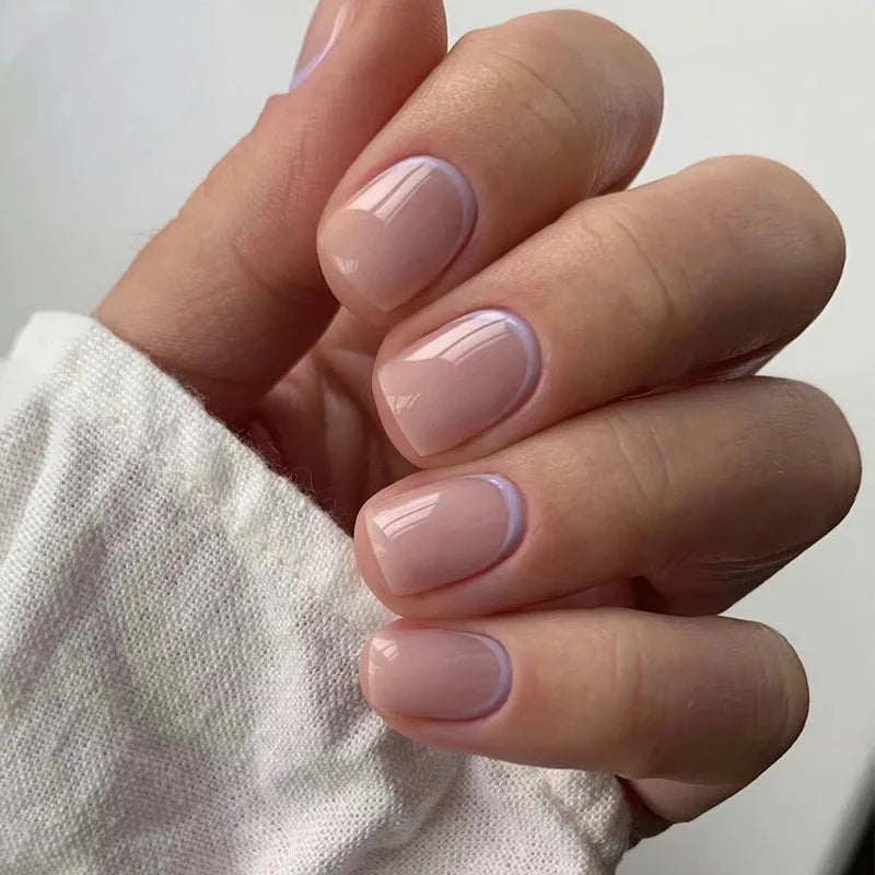 Close-up of a hand displaying light pink and lavender blue floral press-on false nails on fingers
