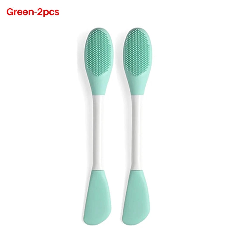 A pair of green silicone facial brushes with white handles for exfoliation
