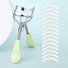 A professional stainless steel eyelash curler set showing the metal curler and a white silicone curler.