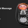 A close-up view of a black shiatsu foot massager device showing various massage rollers and features.