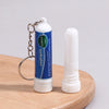 A bottle of nasal inhaler with a metal chain and a white stick is shown on a wooden surface.