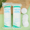 Two packages of Premium Cotton Pads for makeup removal and cleansing are displayed on a wooden surface.
