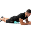 A man is using a Psoas Muscle Massager for deep tissue release on his leg.