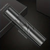 A silver electric nose hair trimmer is shown diagonally on a dark surface with dimension markings.