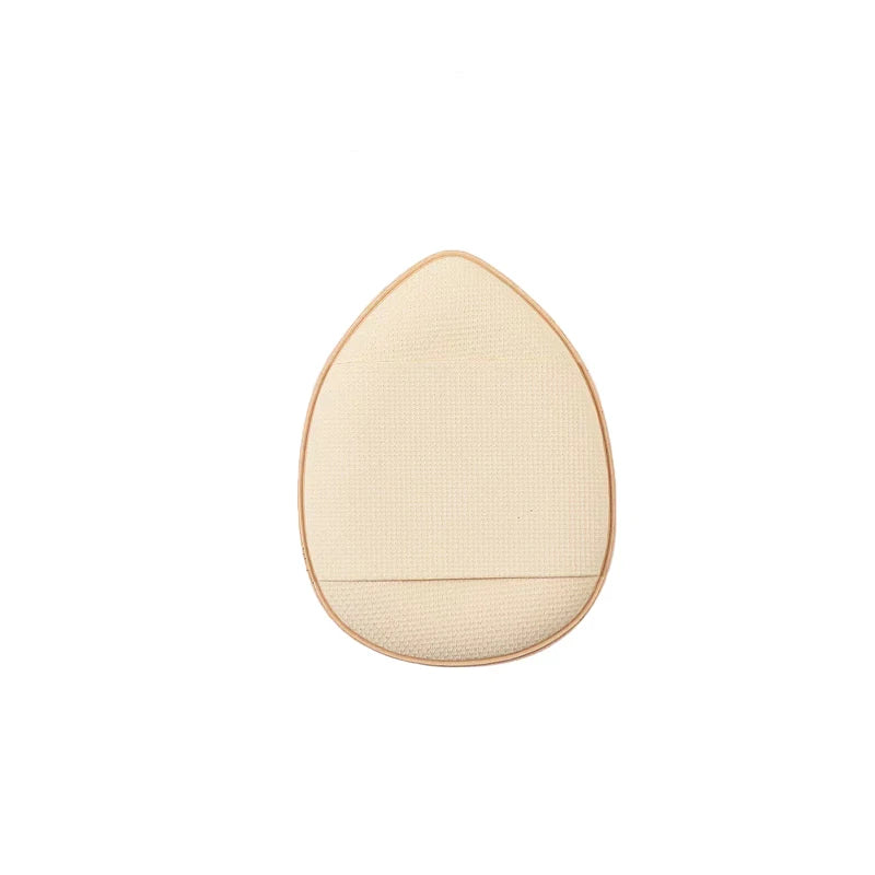 A round, beige silicone applicator tool shaped like an egg for foundation application.