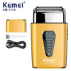 A gold-colored electric beard shaver, model KM-T123, shown with replacement blades and a charging cable.