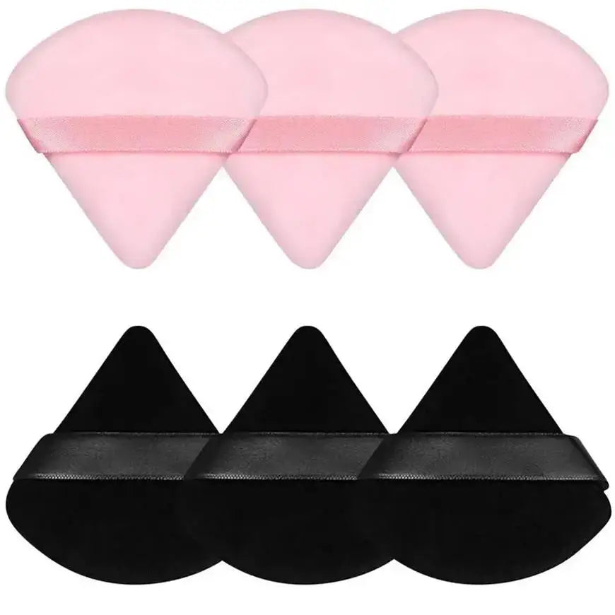 A set of pink and black triangular powder puffs for foundation application.