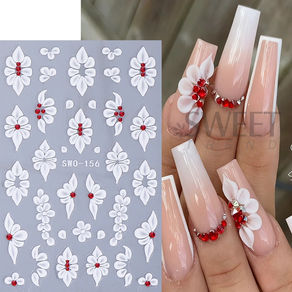 A set of white floral nail stickers featuring red accents and pink manicured nails.