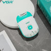 A white and teal VGR electric epilator device is shown on a gray surface next to its packaging box.