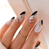 A hand displaying press-on false nails with a French wavy design featuring white and gold accents.