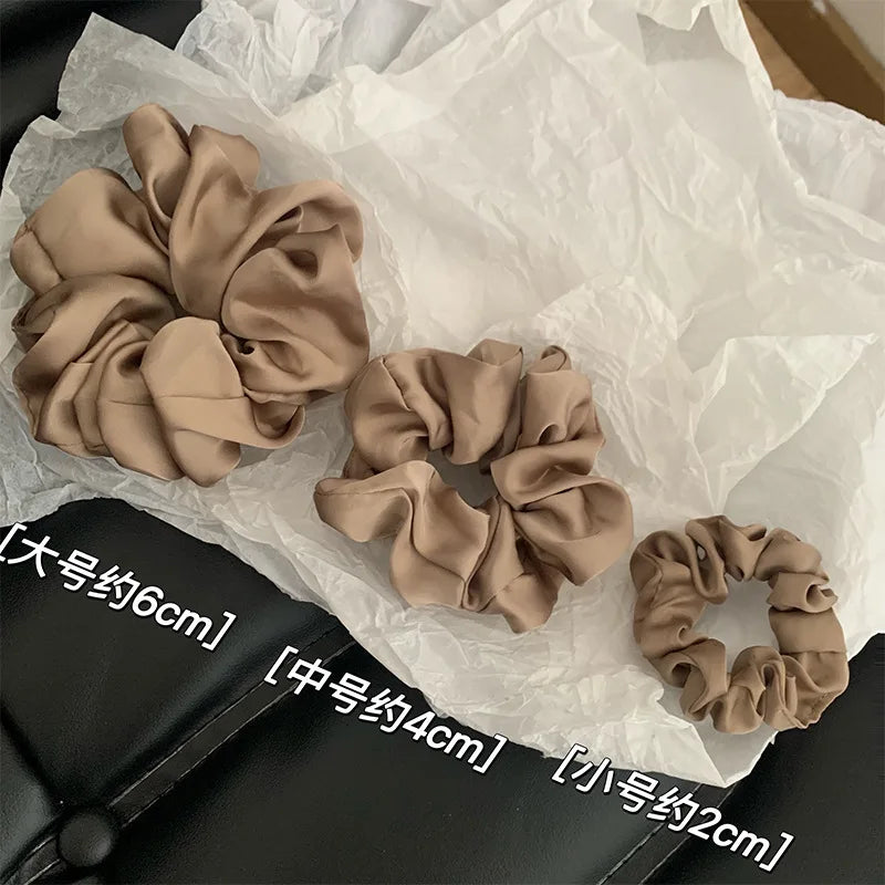 Collection de pinces à cheveux en satin chiffon beige présentées sur du papier de soie avec mesures.