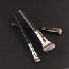 A set of professional makeup brushes with silver ferrules and soft, fluffy bristles displayed on a dark surface.