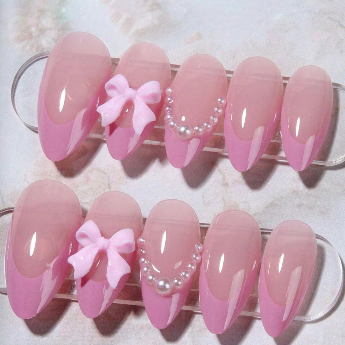 24 pieces of pink heart pearl press-on fake nails displayed on a clear plastic holder.