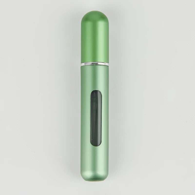 A slender, cylindrical portable refillable perfume bottle in a light green color with a silver band and a black inner section