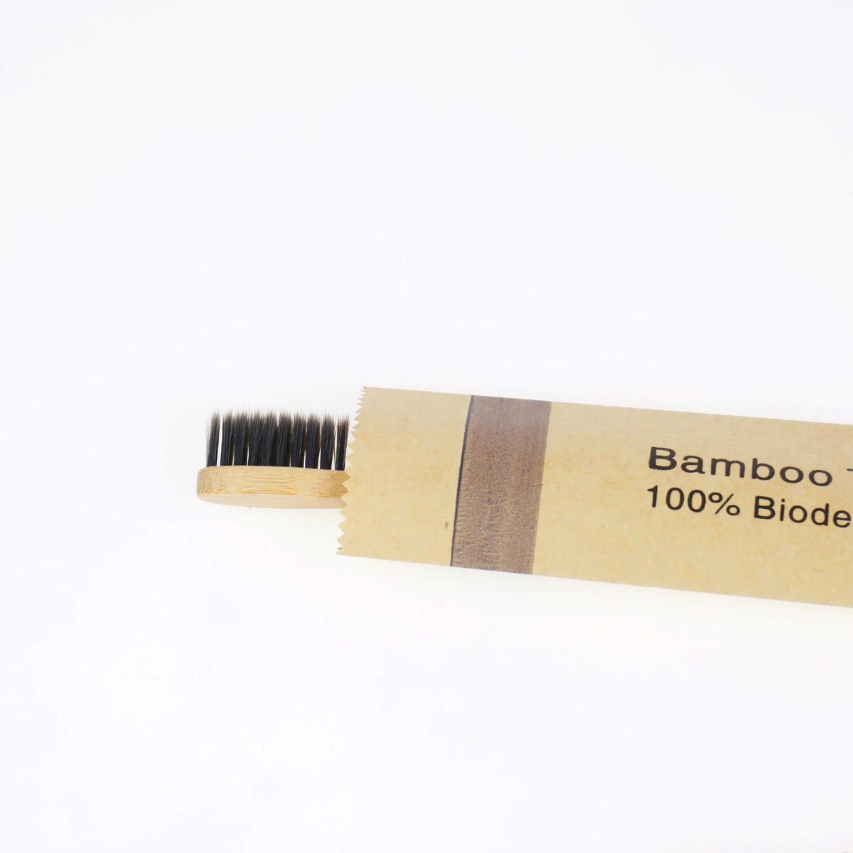 A wooden bamboo toothbrush with soft bristles and brown packaging.