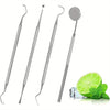 A set of professional multi-tool tooth cleaning instruments including probes and a mirror, next to a lime slice.