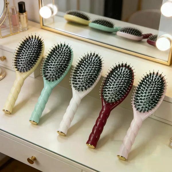 A collection of various colored boar bristle hair brushes displayed on a white vanity surface.