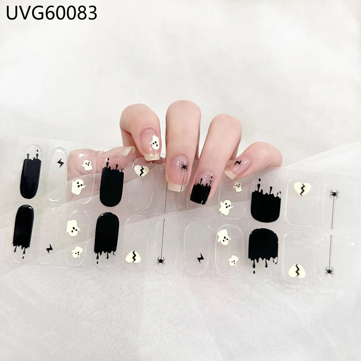 UV gel nail stickers featuring black and white Halloween designs applied to a hand.