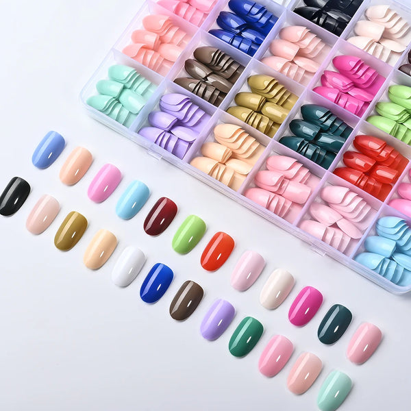 A variety of glossy press-on nails in 24 colors are displayed in an organized plastic kit.