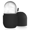 Rouléuse à glaçons en silicone noire avec une tête de pierre arrondie et transparente, sur une surface réfléchissante.