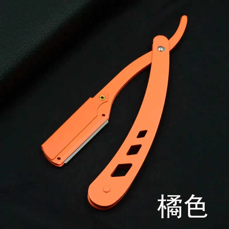 Couteau de rasage antique orange pliable avec manche et lame sur fond noir.