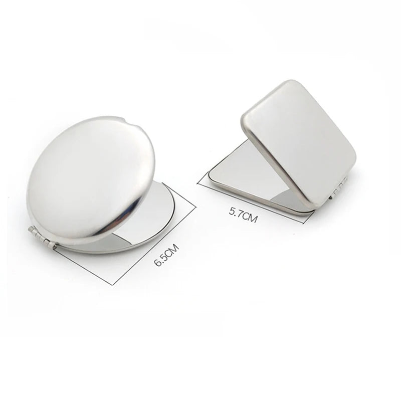 A stainless steel folding mirror with a round surface and a rectangular cover, shown in a side view.