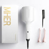A white professional beach waver curling iron and a black flat iron are displayed next to a gold branded box.