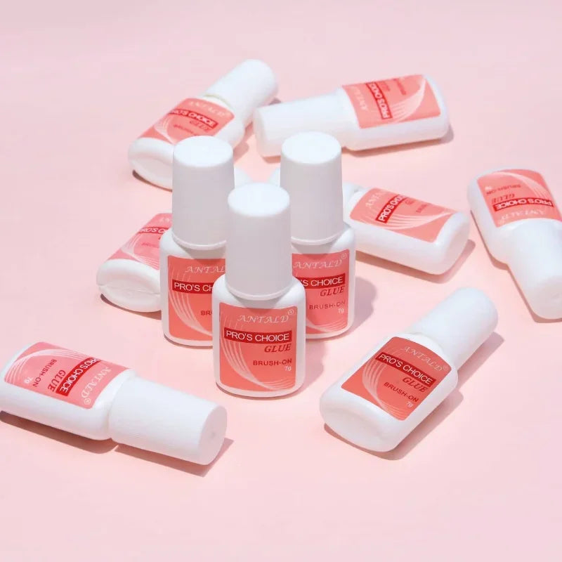 Various bottles of Pro's Choice Glue for acrylic art nail glue displayed on a pink background.