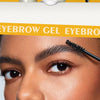 Close-up of a woman applying eyebrow gel to her brows for definition.