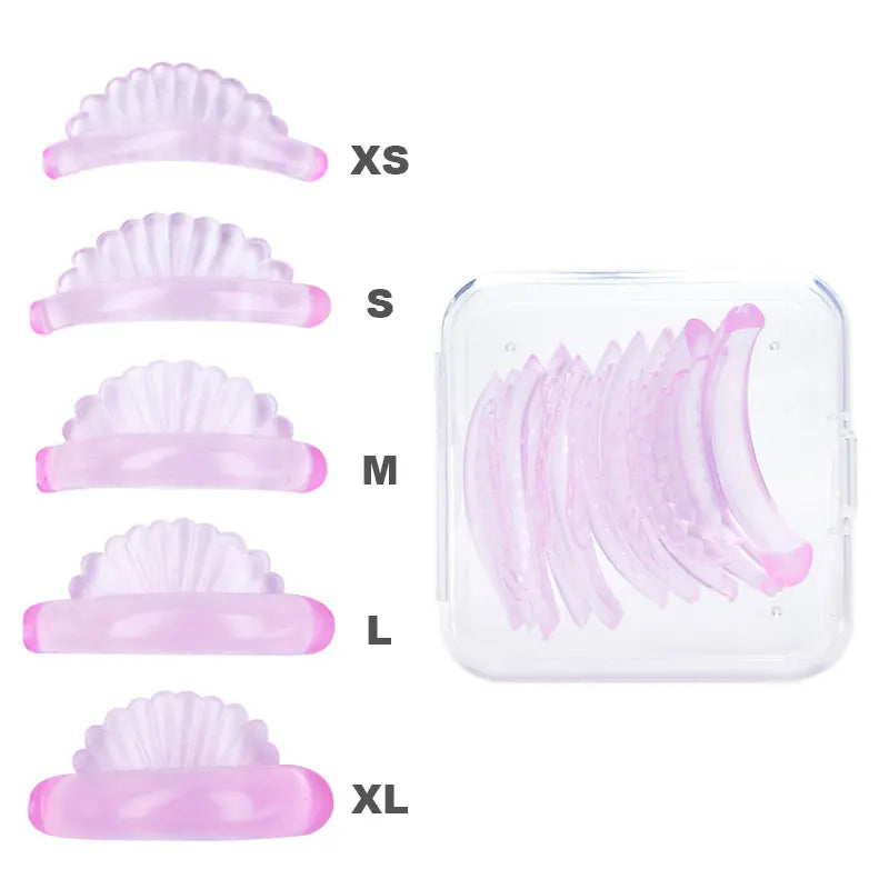 A set of pink silicone eyelash curlers in various sizes XS to XL displayed next to a clear plastic container.
