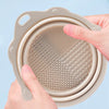 A hand is holding a silicone makeup brush cleaner and drying stand set with a perforated silicone mat.