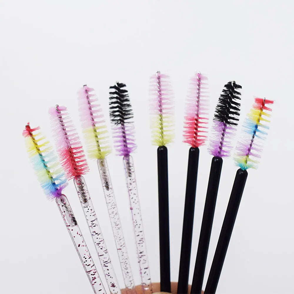 Un ensemble de pinceaux à cils jetables multicolores avec des nuances de rose, de violet et de vert.