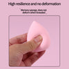 A hand is holding a pink makeup sponge, demonstrating its resilience and ability not to deform.