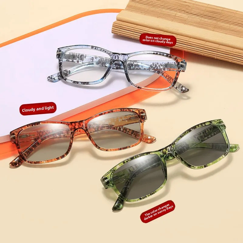 A set of photochromic reading glasses in various shades of brown and green, shown on a light background.