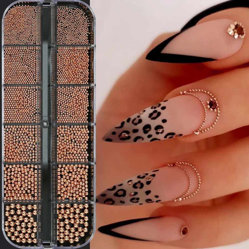 A close-up of gold mixed stainless steel bead nail art decorations applied to fingernails.