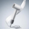A white professional high-speed hair dryer is shown in a close-up, angled view against a light gray background.