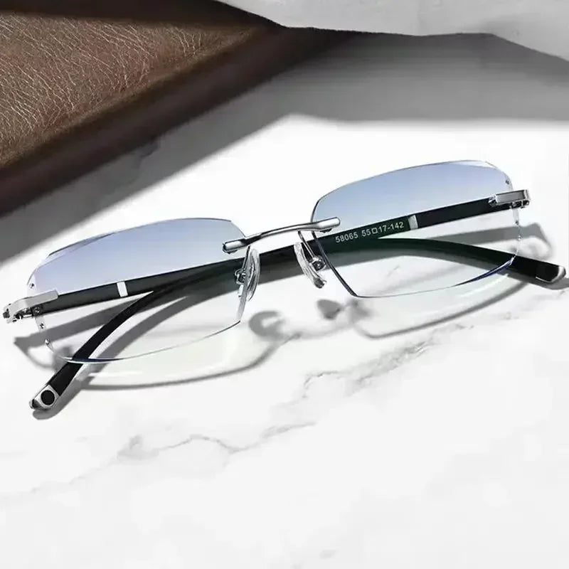 A pair of silver-framed photochromic reading glasses resting on a white marble surface.