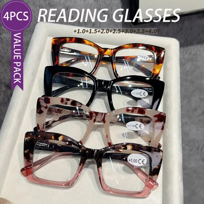 A white box containing four pairs of tortoiseshell reading glasses with various lens additions.