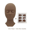 A realistic silicone mannequin head with a box of boxed eyelash extensions for practice.