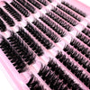 A close-up of pink lash clusters with long black false eyelashes arranged in rows.