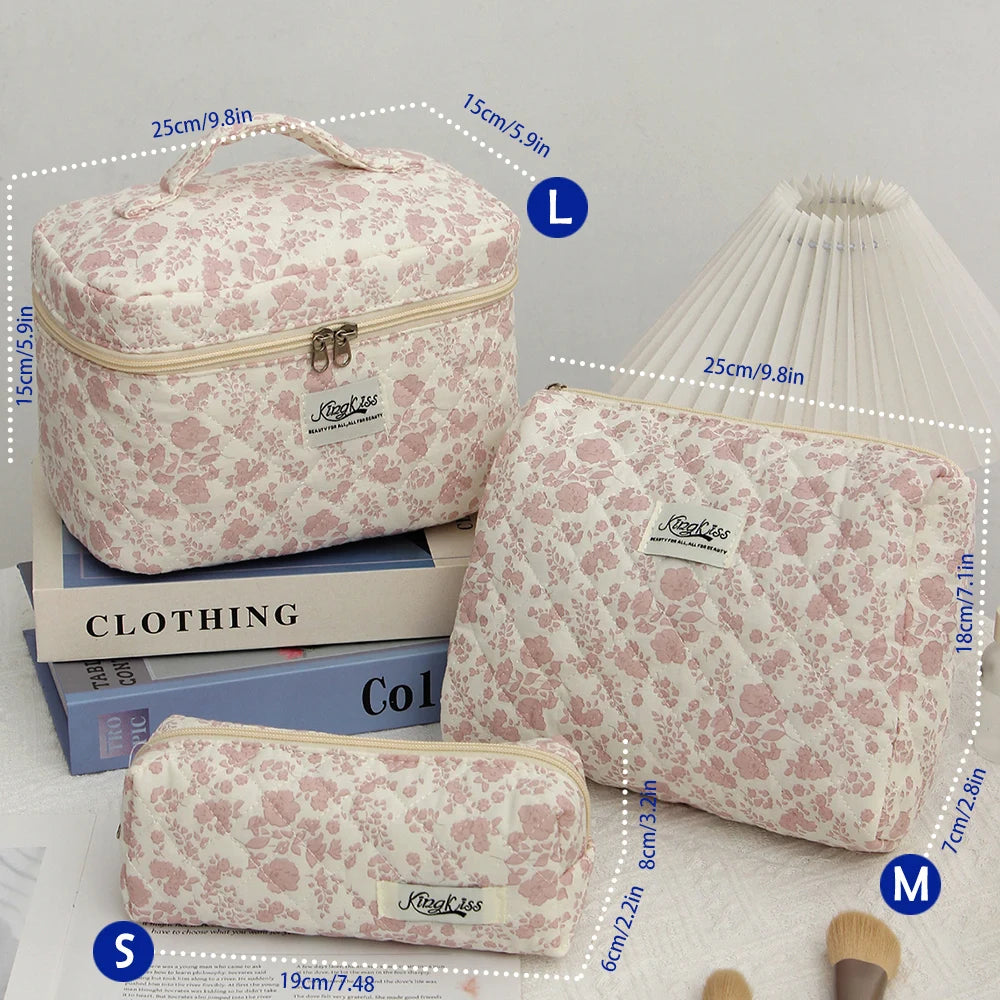 A set of pink floral quilted cotton makeup bags in various sizes L, M, and S displayed next to a white cylindrical object.